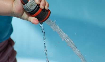 main d'enfant versant de l'eau avec un tuyau d'eau